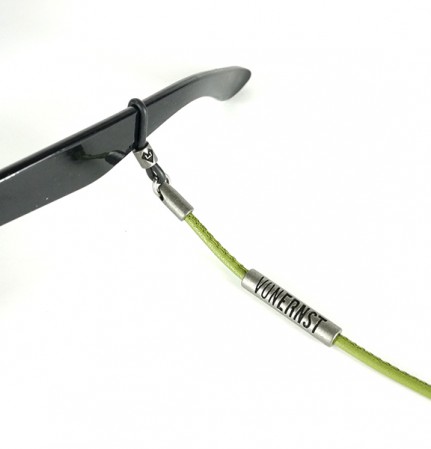 VONERNST Leder Brillenband kaktus grün mit typischen VONERNST Brandings am Label und den Gummiösen Detailaufnahme Brille